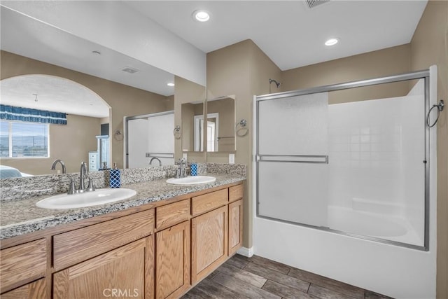 bathroom featuring enclosed tub / shower combo and vanity