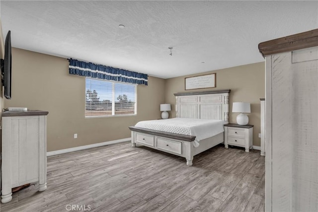 bedroom with light hardwood / wood-style floors and a textured ceiling