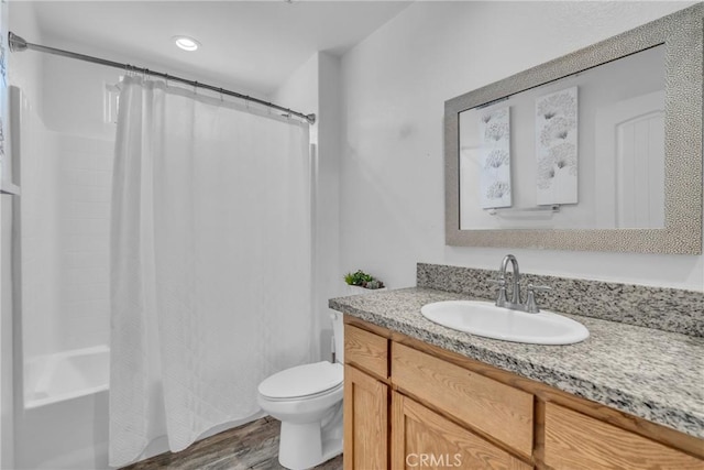 full bathroom featuring vanity, wood-type flooring, shower / bathtub combination with curtain, and toilet