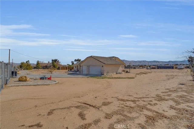 view of yard featuring a mountain view and a garage