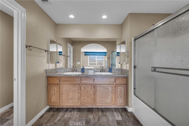 bathroom featuring vanity, bath / shower combo with glass door, and hardwood / wood-style floors