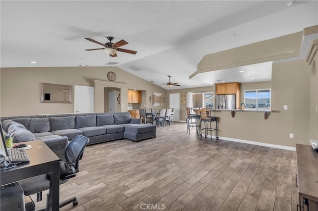 living room featuring vaulted ceiling, ceiling fan, and light hardwood / wood-style floors