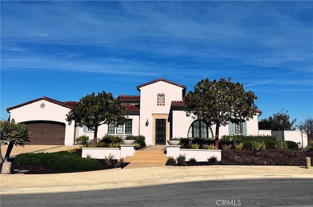 mediterranean / spanish-style house with a garage