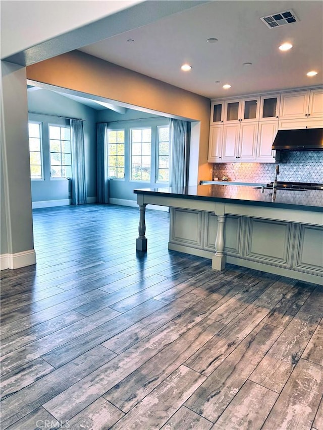 kitchen with dark hardwood / wood-style floors, decorative backsplash, and gas stovetop