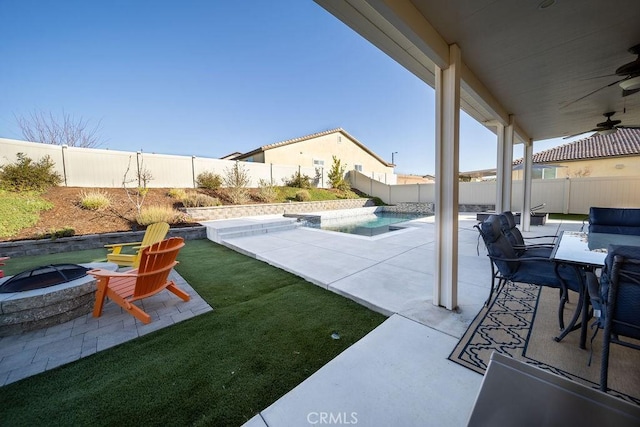 view of patio / terrace featuring a fenced in pool, ceiling fan, and an outdoor fire pit