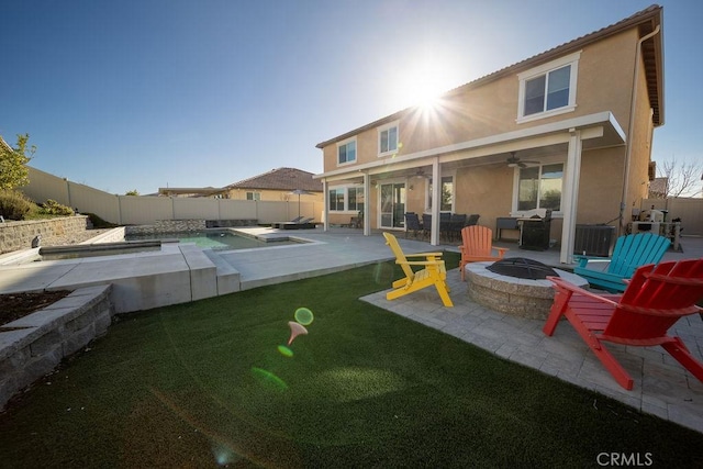 rear view of house featuring a patio area, central air condition unit, a yard, a fenced in pool, and a fire pit