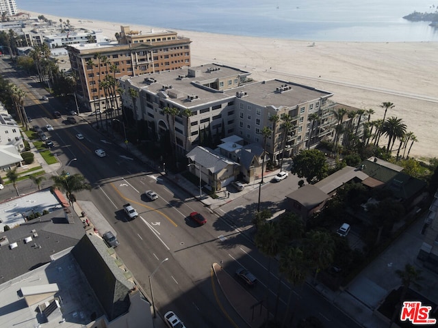 birds eye view of property with a water view and a beach view