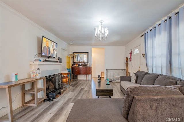 living room with crown molding, a notable chandelier, and light hardwood / wood-style flooring