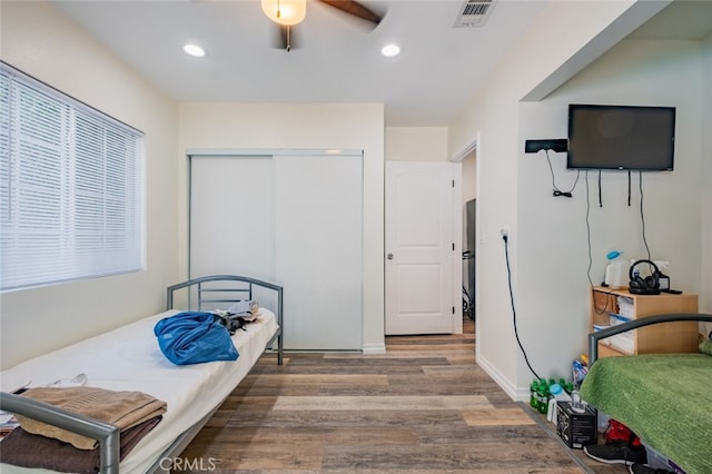 bedroom with ceiling fan, wood-type flooring, and a closet