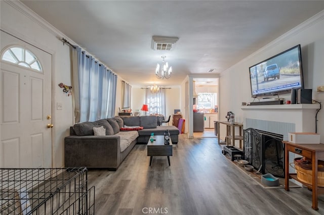 living room with hardwood / wood-style flooring, crown molding, and an inviting chandelier