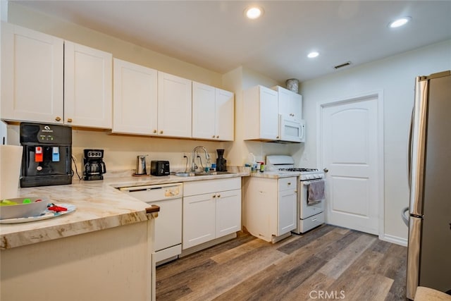 kitchen with white appliances, dark hardwood / wood-style flooring, sink, and white cabinets