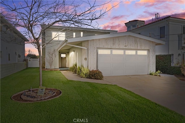 front facade with a garage and a lawn