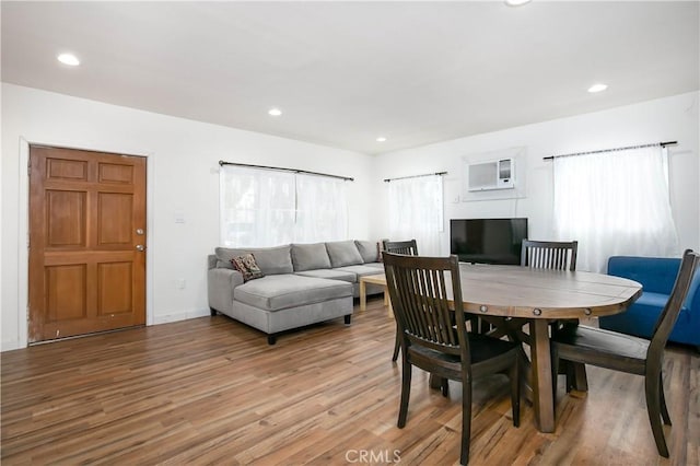 dining area with light hardwood / wood-style flooring and a wall mounted AC