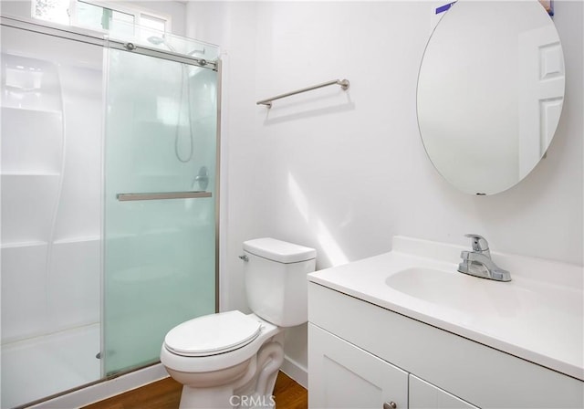 bathroom featuring vanity, toilet, an enclosed shower, and wood-type flooring