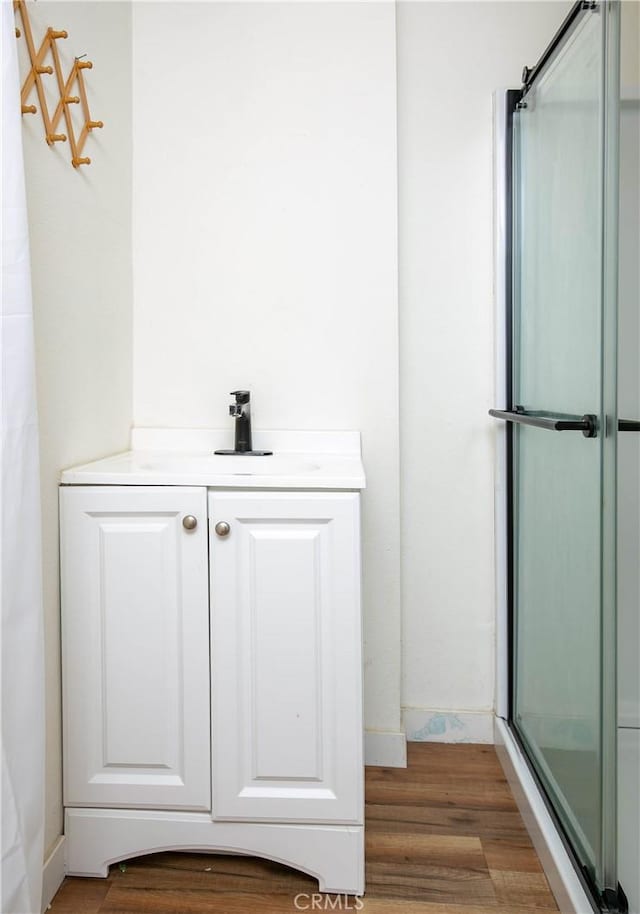 bathroom featuring vanity, wood-type flooring, and walk in shower