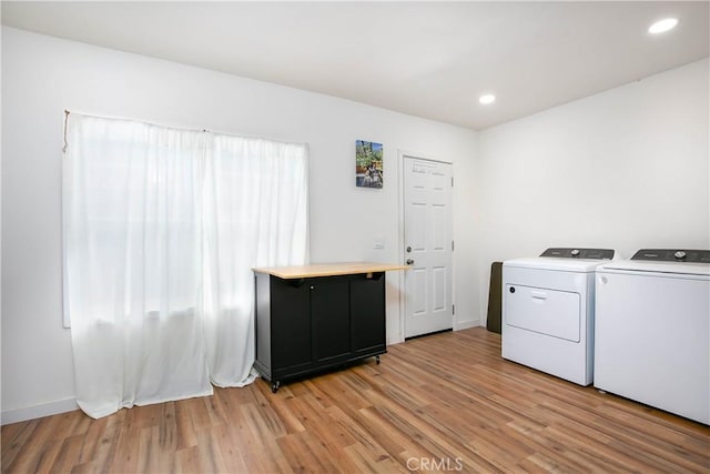 laundry room featuring independent washer and dryer and light hardwood / wood-style floors