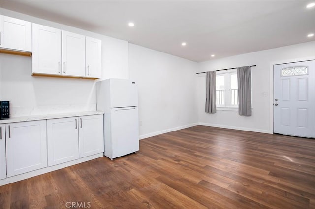 kitchen with white refrigerator, dark hardwood / wood-style floors, and white cabinets