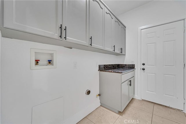 laundry room with cabinets, hookup for a washing machine, and light tile patterned floors