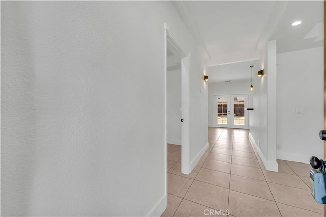 hallway with french doors and light tile patterned floors