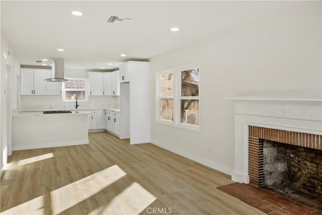 unfurnished living room with a fireplace and light hardwood / wood-style floors