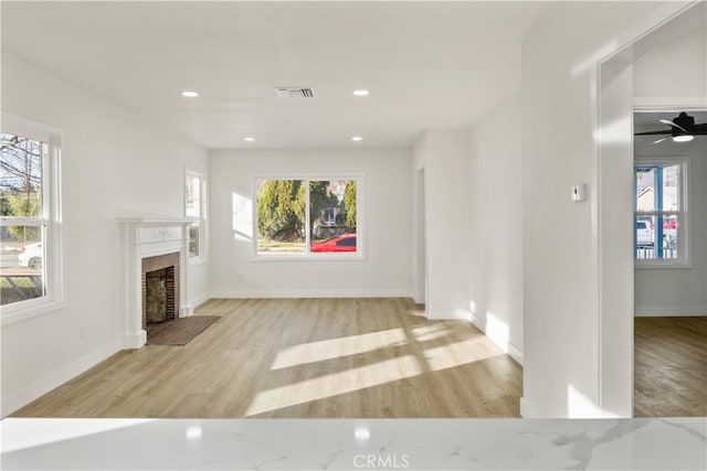 unfurnished living room with light hardwood / wood-style flooring and a wealth of natural light