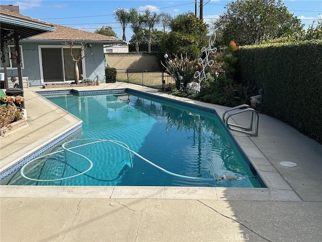 view of swimming pool featuring a fenced in pool, fence, and a patio