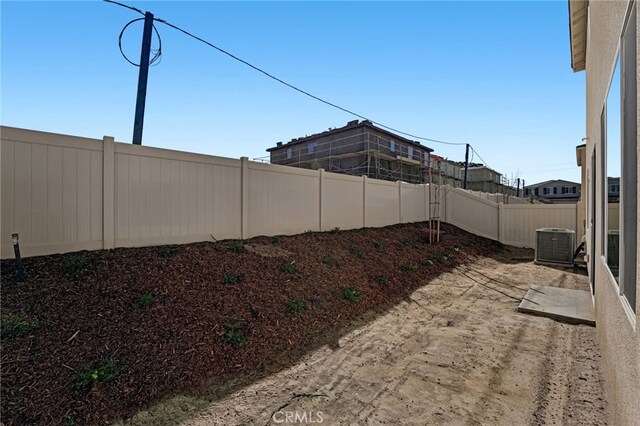 view of yard featuring central AC unit and a fenced backyard