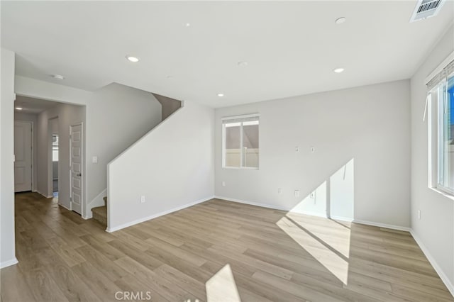 unfurnished living room with recessed lighting, visible vents, light wood-style floors, plenty of natural light, and stairs