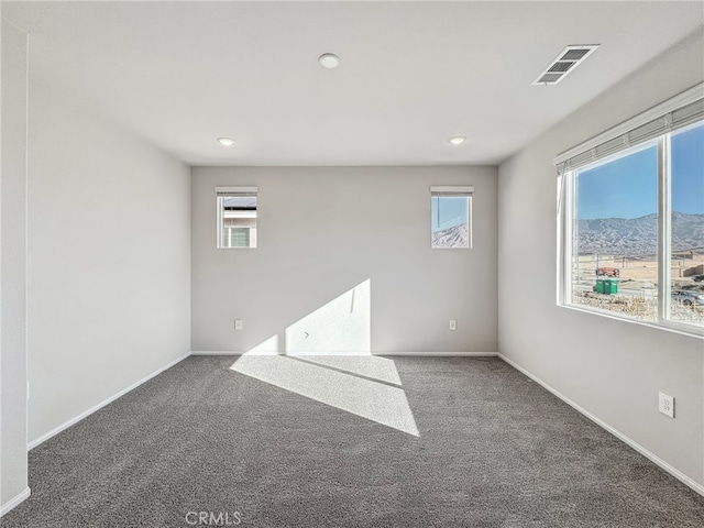 carpeted empty room featuring visible vents and baseboards