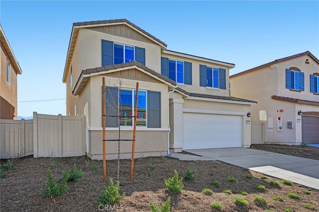 view of front facade with a garage, concrete driveway, fence, and stucco siding