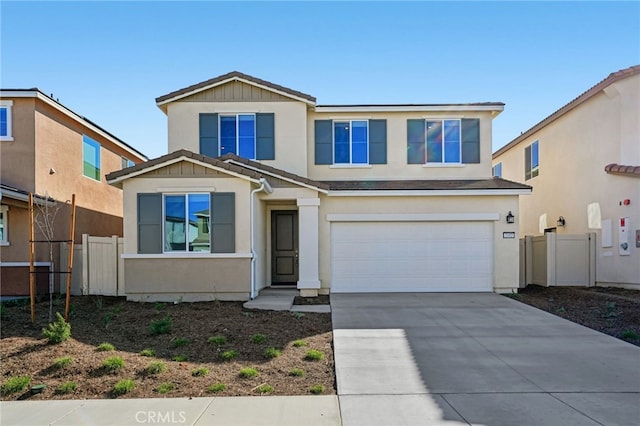 traditional home with a garage, fence, driveway, and stucco siding