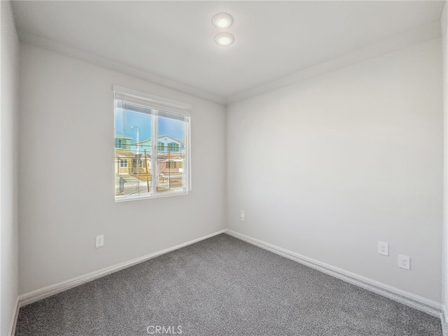 unfurnished room with carpet floors and baseboards