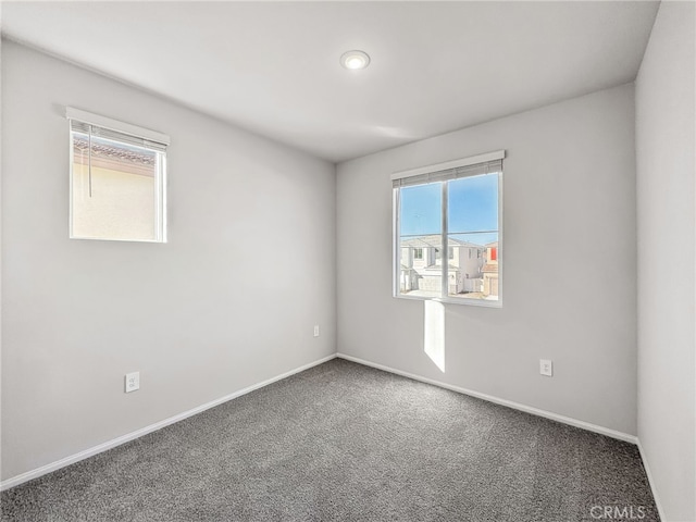 carpeted empty room featuring baseboards