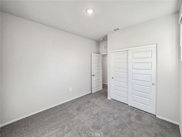 unfurnished bedroom featuring carpet floors, a closet, visible vents, and baseboards