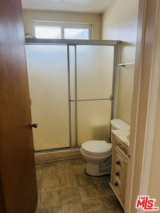 bathroom featuring vanity, toilet, and walk in shower