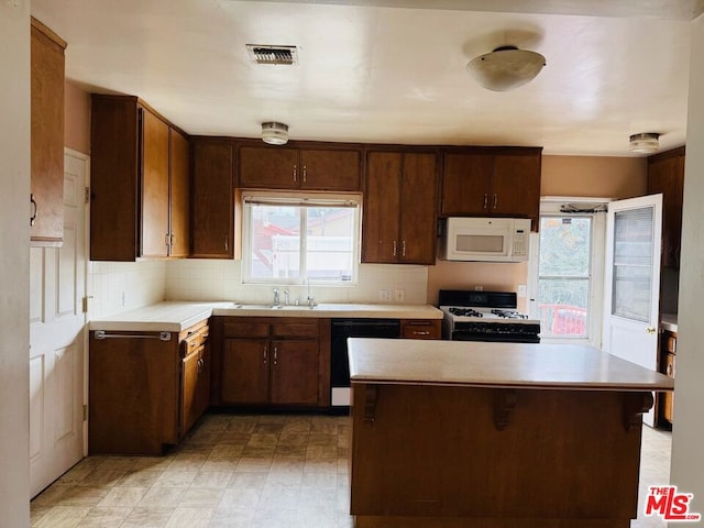 kitchen with white appliances, dark brown cabinets, sink, and decorative backsplash