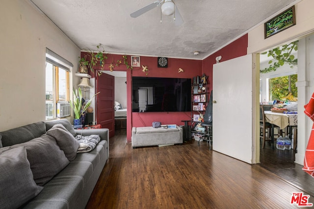 living room with ceiling fan, dark wood-type flooring, cooling unit, and a textured ceiling