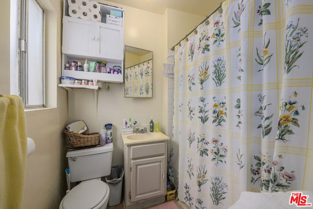 bathroom with a shower with curtain, vanity, and toilet