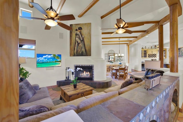 living area featuring ceiling fan, beam ceiling, tile patterned flooring, and a tile fireplace