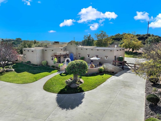 rear view of property featuring stucco siding and a lawn