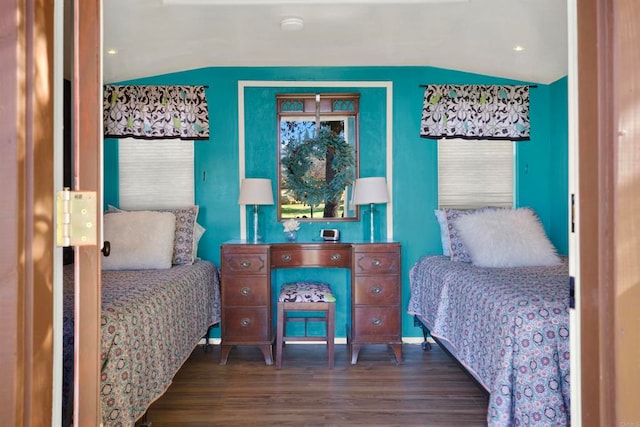 bedroom featuring baseboards, lofted ceiling, and wood finished floors