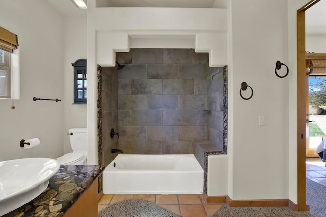 bathroom featuring toilet, tile patterned flooring, baseboards, bathing tub / shower combination, and vanity