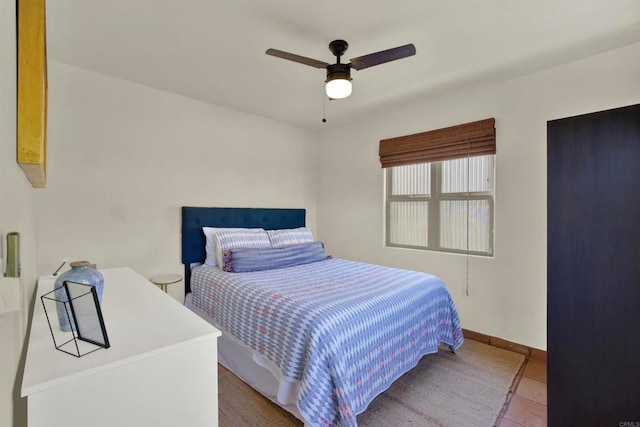 bedroom featuring tile patterned flooring, baseboards, and ceiling fan