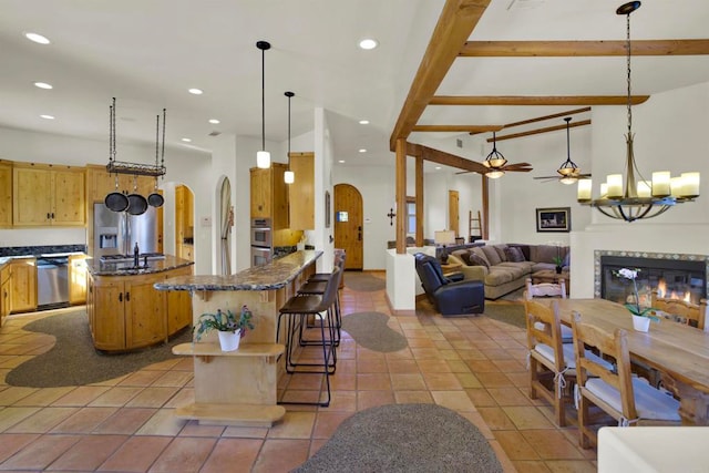 kitchen featuring arched walkways, recessed lighting, stainless steel appliances, and a high end fireplace