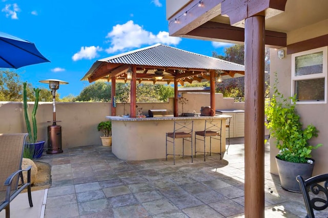 view of patio / terrace with a gazebo, outdoor dry bar, and fence