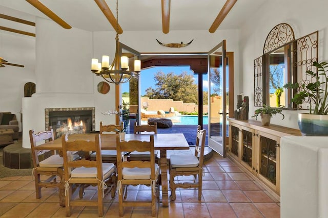 tiled dining space with a glass covered fireplace, an inviting chandelier, and beamed ceiling