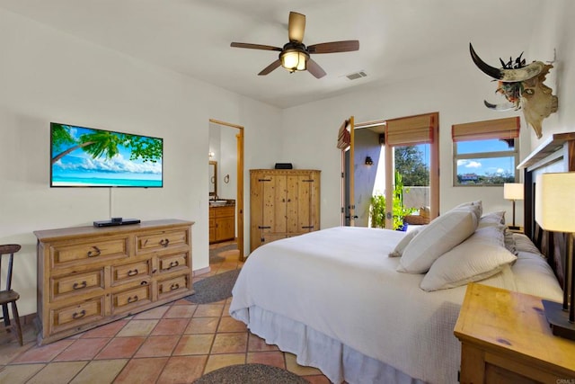 bedroom featuring visible vents, a ceiling fan, ensuite bath, light tile patterned flooring, and access to exterior