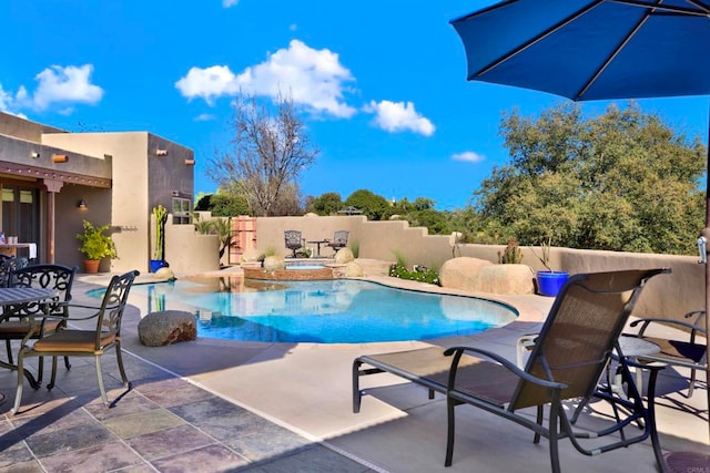 view of swimming pool featuring a fenced in pool, fence, an in ground hot tub, and a patio area