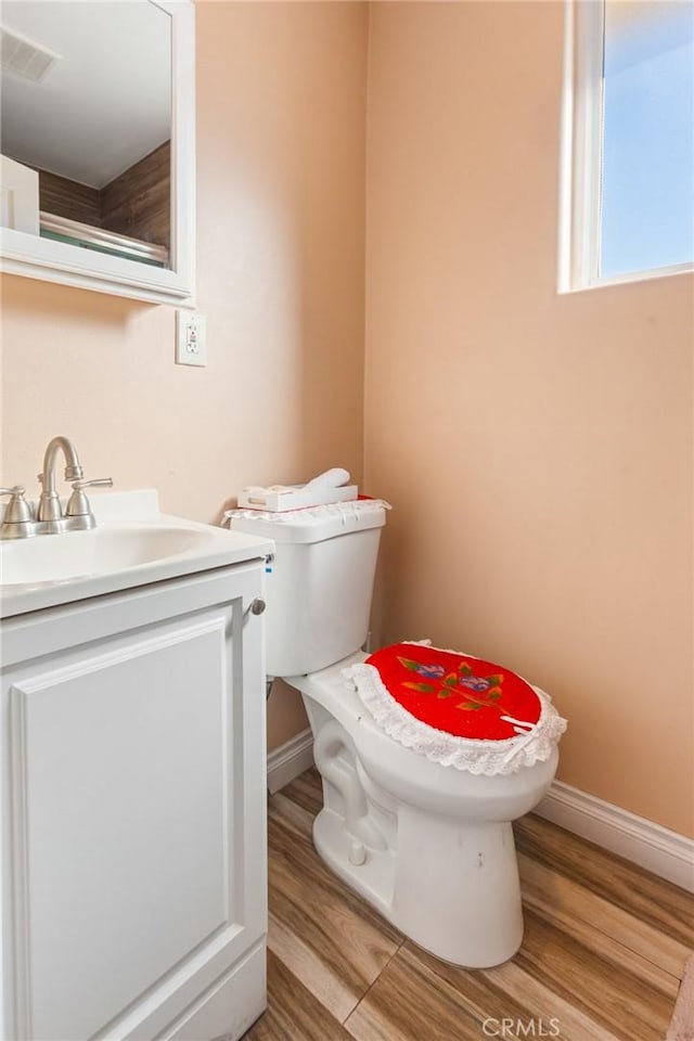 bathroom featuring vanity, hardwood / wood-style flooring, and toilet