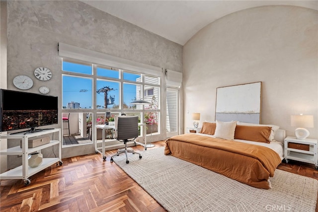 bedroom with parquet flooring and high vaulted ceiling